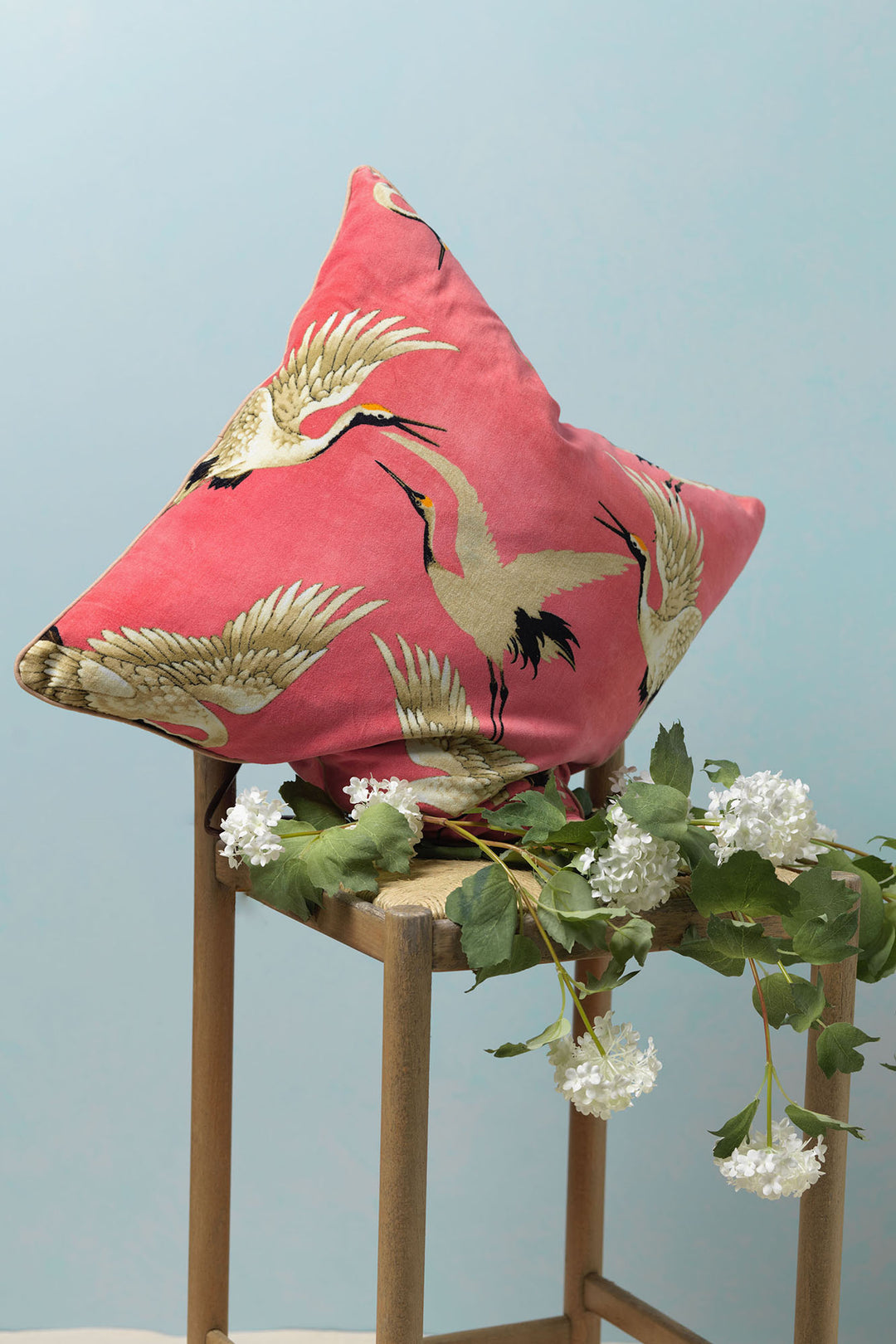 The One Hundred Stars Stork Crane Lipstick Pink Square Velvet Cushion features a pattern of white and black storks on a vivid pink background.