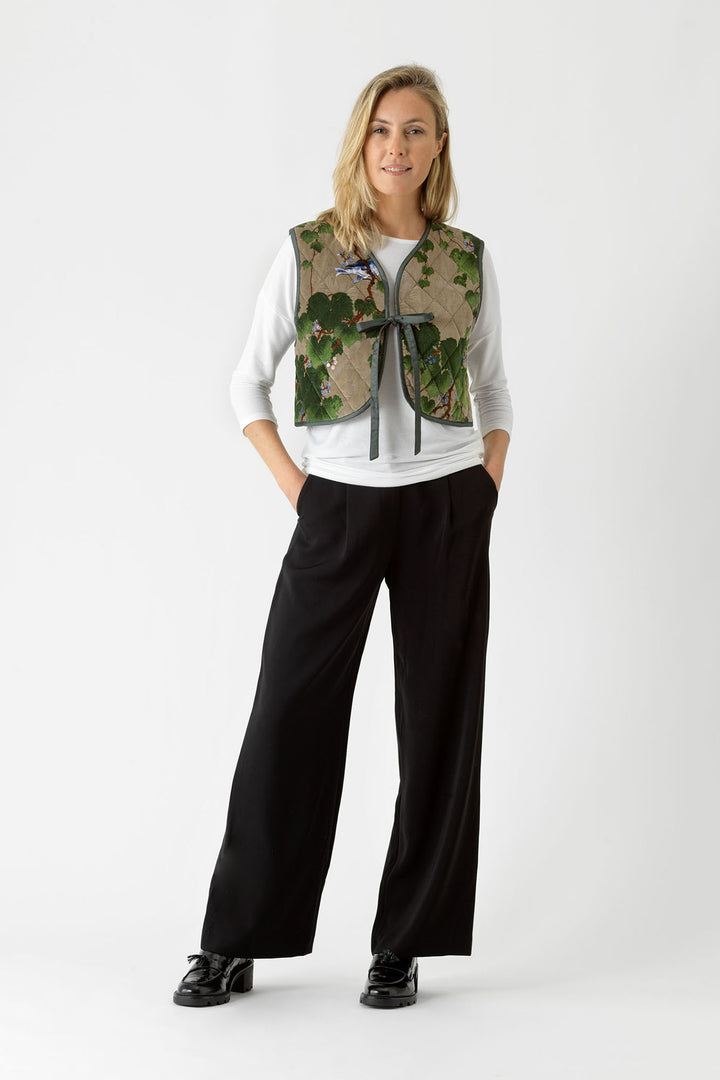 Velvet ladies gilet with green maple leaf pattern on a stone background by One Hundred Stars