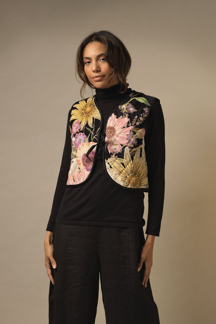 ladies short velvet tie gilet with a floral daisy print on a black background by One Hundred Stars