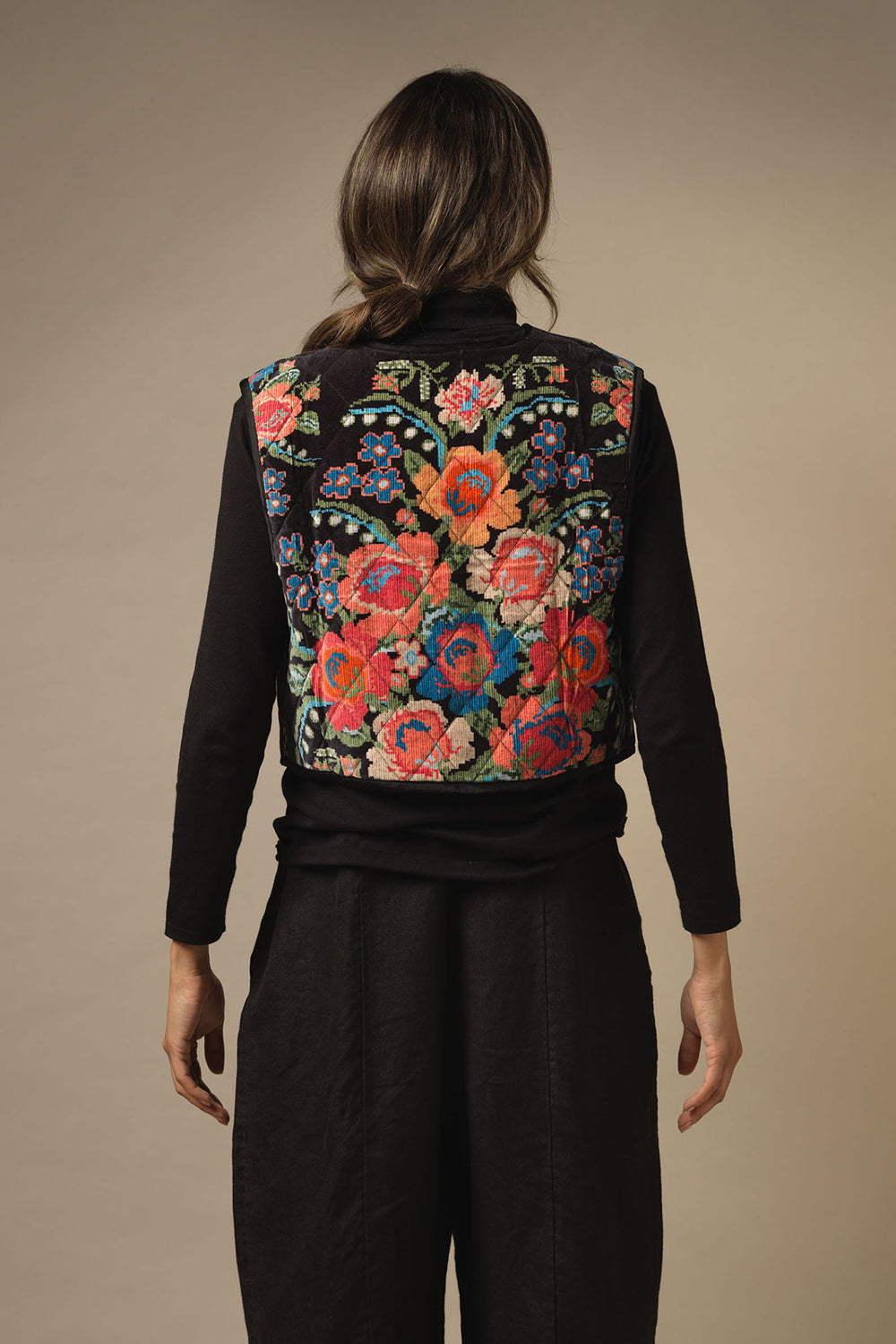 ladies velvet luxury gilet in woven flower print featuring colourful flowers on a black background by One Hundred Stars