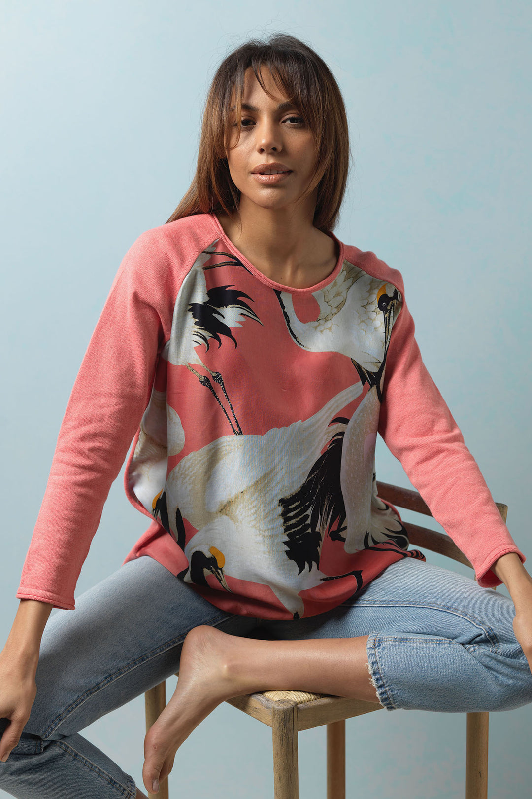 One Hundred Stars Stork Crane Lipstick Pink Cotton Jumper features a black and white stork print on the front, on a vivid pink background. 